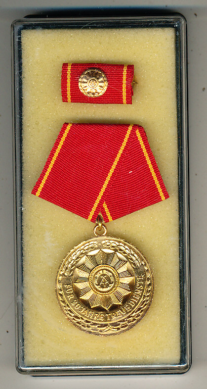 DDR. Dienstmedaille am roten Band mit gelben Streifen in Messing. Verleihungs Medaille Für 20 Jahre