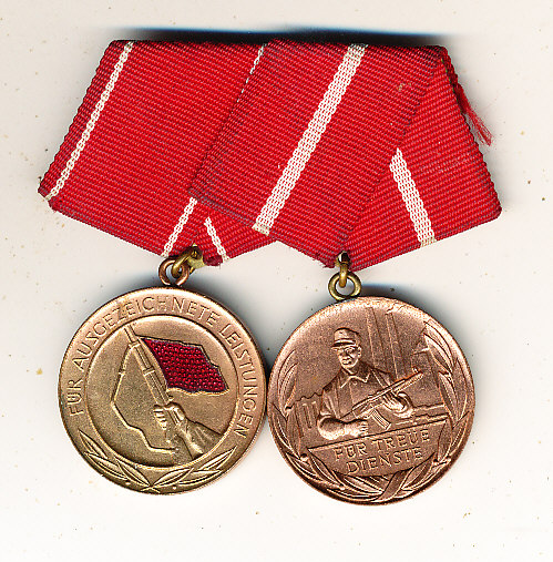 DDR. 2 Dienstmedaillen am roten Band mit weißen Streifen in Messing.Verl.-Medaille Für Treue Dienste